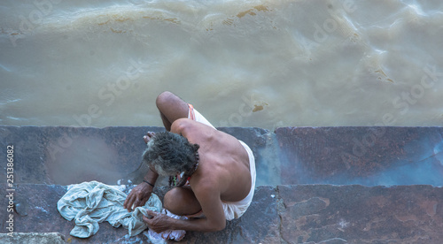Hombre de espaldas lavando ropa en el río Ganges, en Varanasi, India. Foto Aérea photo