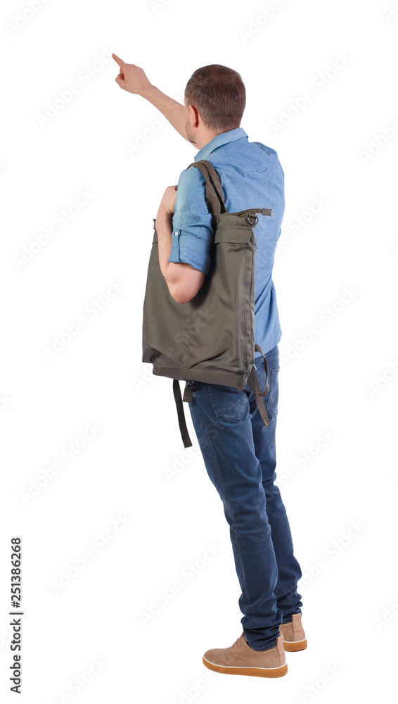 Back view of a man with a green backpack pointing forward. Back view of a man with a green backpack pointing forward.