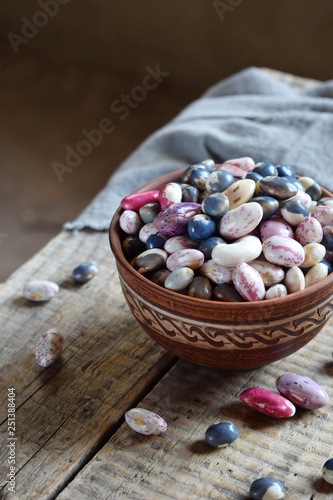 Assortment of young legumes and beans of different varieties and colors in a clay bowl. Raw food. Healthy diet concept. Selective focus