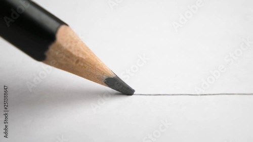 extreme close up of architect or artist draws a line in pencil. schoolboy drawing a flat line with a black pencil. Artists hands drawing wooden pencil writes line on paper. tracking shot
