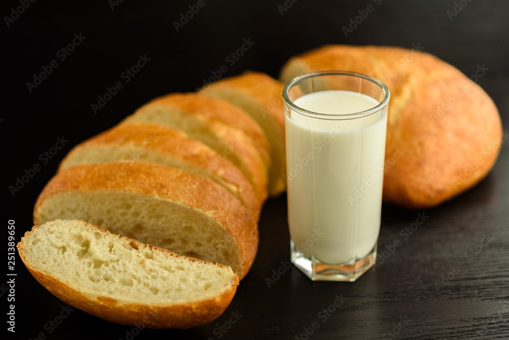 Ciabatta and a glass of milk on a wooden background. Ciabatta and a glass of milk on a wooden background.
