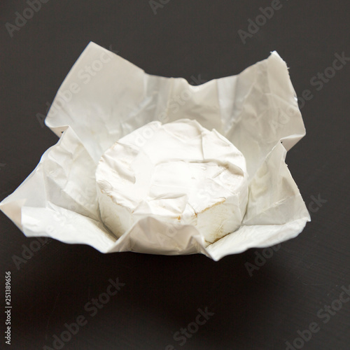 Cheese camembert or brie on black background, side view. Milk production. Close-up.