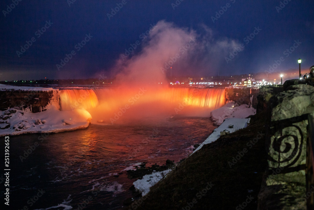 Niagara Falls CANADA - February 23, 2019: Beautiful night Winter frozen idyll at Horseshoe Falls illuminated with colorful lights, the Canadian side of Niagara Falls