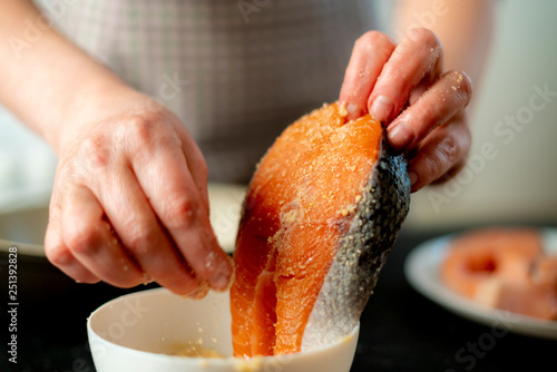 Photography womans hands breading fish at the kitchen
