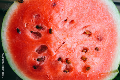 Juicy watermelon lying on the table. Summer fruit. Vegetarian healthy raw diet. Vertical photo.