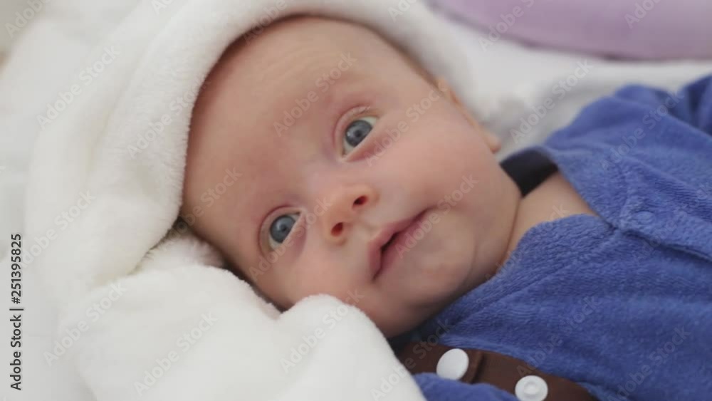 baby boy is lying in the crib, looks at his parents. baby calm and clean baby boy is lying in the crib, looks at his parents. baby calm and clean