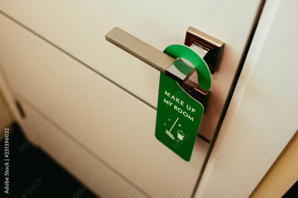 door handle with green symbol with make up my room lettering, cleaning service in hotel door handle with green symbol with make up my room lettering, cleaning service in hotel
