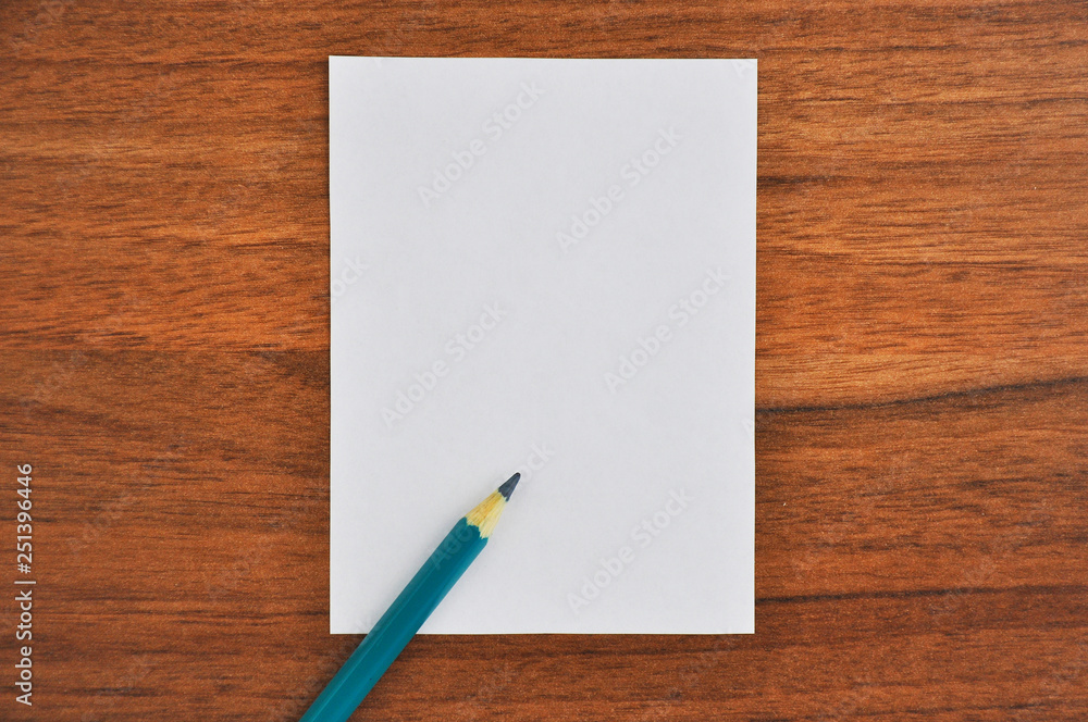 White paper and pencil on wooden table White paper and pencil on wooden table