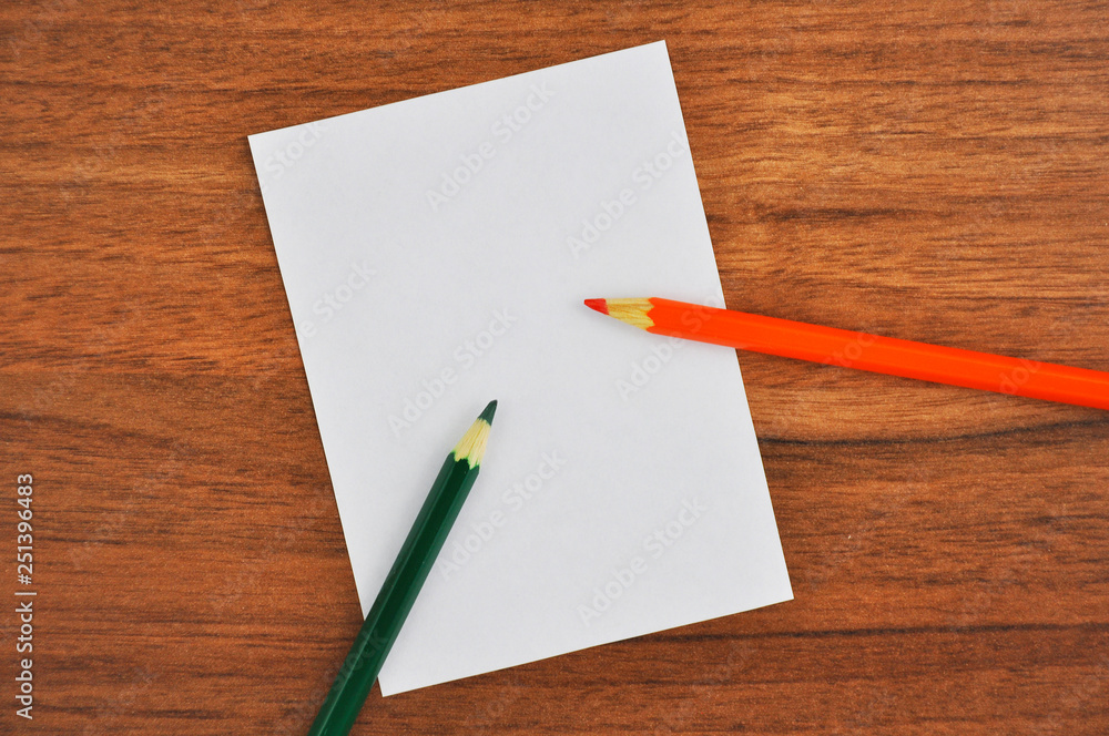 White paper and pencil on wooden table White paper and pencil on wooden table