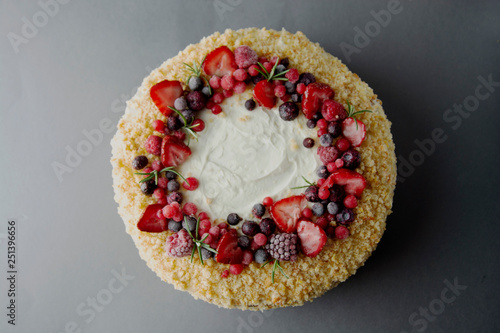 Homemade sponge cake with cream and fresh berries. Carrot and orange cake, decorated with berry. sweet dessert. Whole deliciouse cake. Gray background.