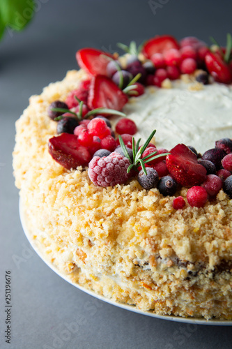 Homemade sponge cake with cream and fresh berries. Carrot and orange cake, decorated with berry. Close up sweet dessert. Whole deliciouse cake. Gray background.