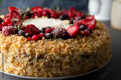 Homemade sponge cake with cream and fresh berries. Carrot and orange cake, decorated with berry. sweet dessert. Whole deliciouse cake. Gray background.