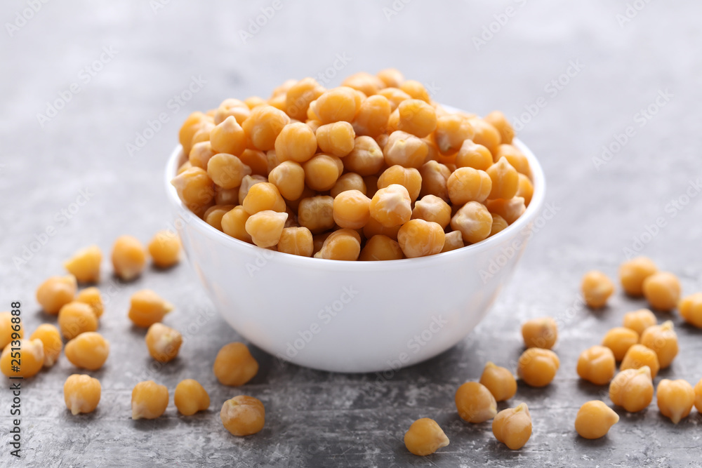 Roasted chickpeas in white bowl on grey wooden table Roasted chickpeas in white bowl on grey wooden table