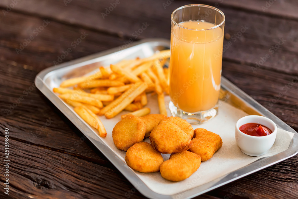 Close up chicken nuggets and fries with sauce and juice on plate Close up chicken nuggets and fries with sauce and juice on plate
