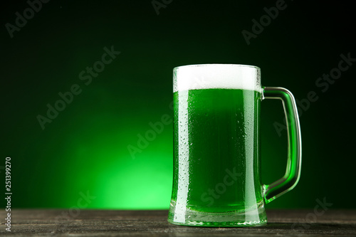 St. Patrick's Day. Glass mug with green beer on dark background