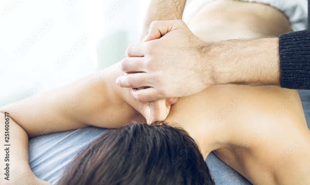 Fototapeta premium Close-up of a physiotherapist massaging the neck of a beautiful young woman. Concept of health treatments and physiotherapy