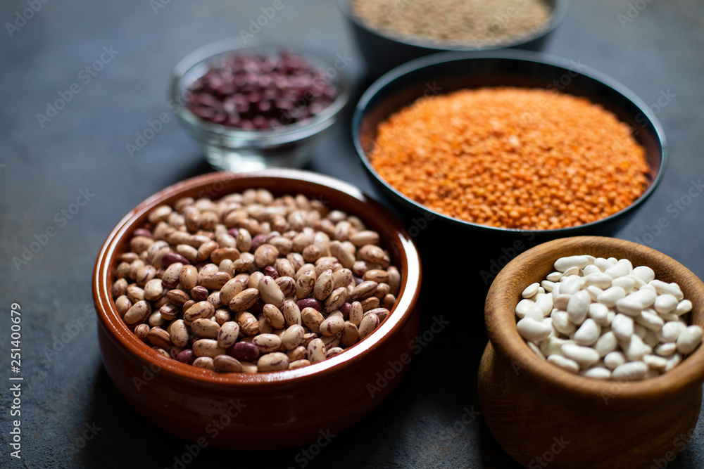 Assortment of legumes: beans and lentils. Raw healthy food. Vegetable protein. Dark background. Close up. Space for text Assortment of legumes: beans and lentils. Raw healthy food. Vegetable protein. Dark background. Close up. Space for text