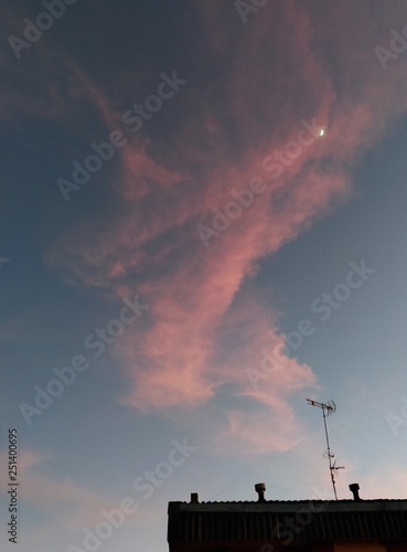 Luna y nubes rosas en el atardecer.