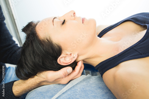 Close-up of a physiotherapist massaging the neck of a beautiful young woman. Concept of health treatments and physiotherapy