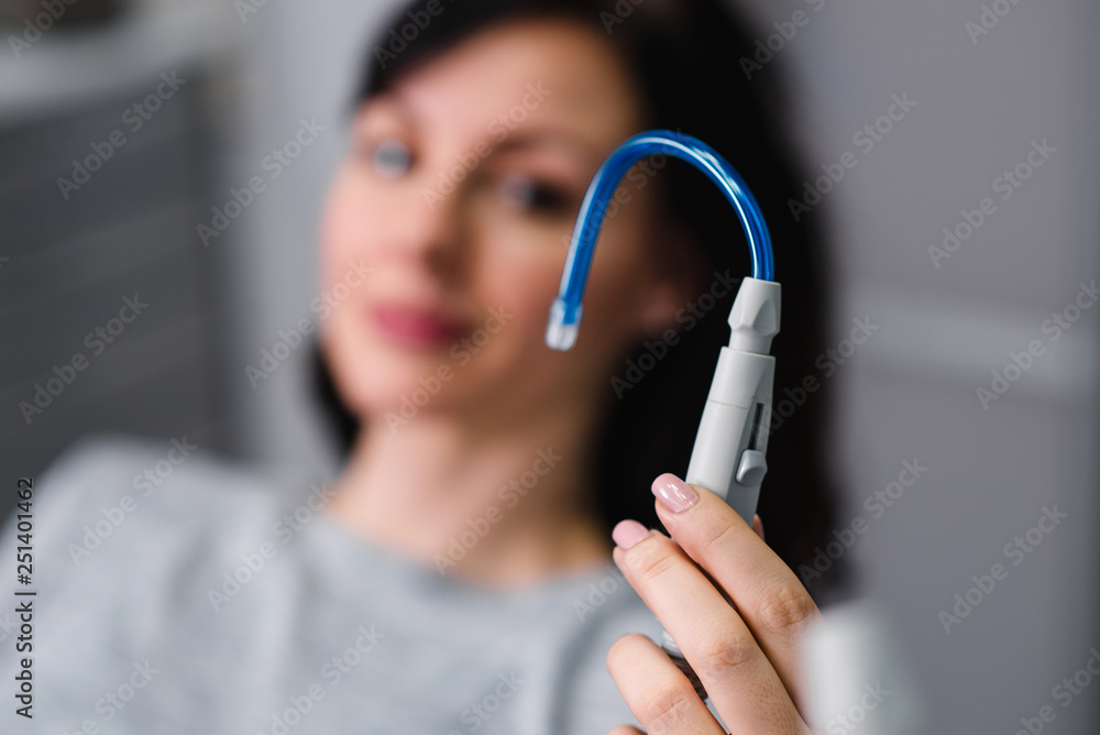 Holding dental suction tube instrument. StockFoto Adobe Stock
