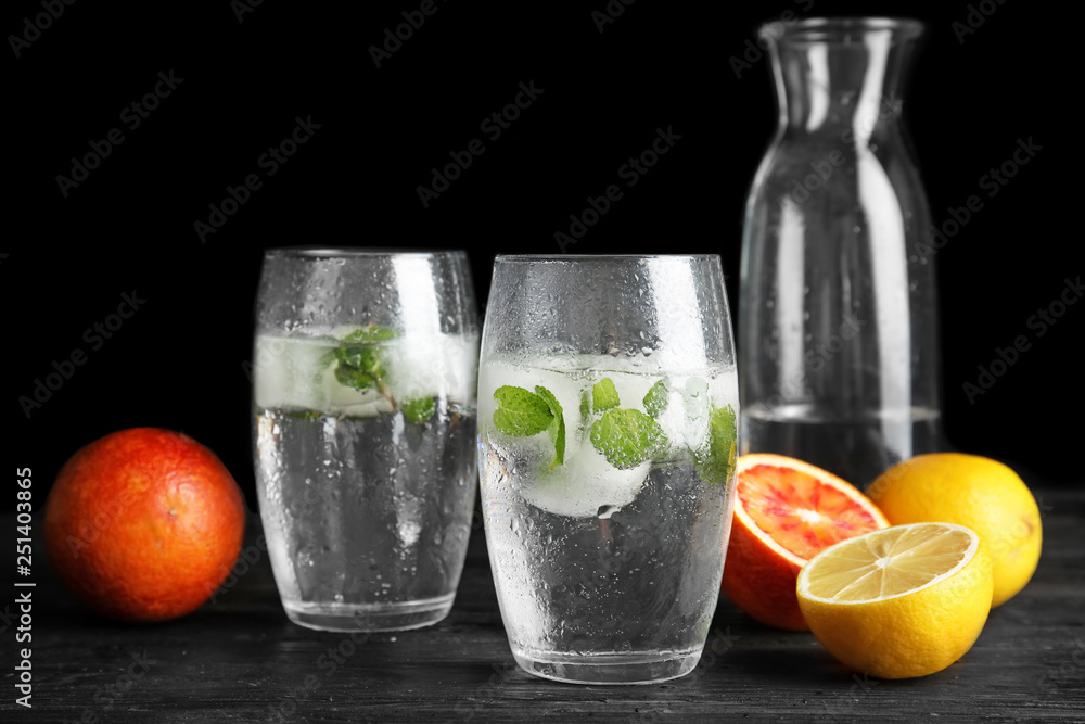 Fototapeta premium Composition with refreshing drink with mint and ice cubes in glasses on dark background