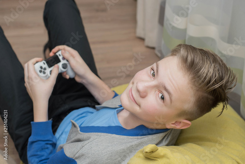 Teenager playing video games at home. gaming game play tv fun gamer gamepad guy controller video console playing player holding hobby playful enjoyment view concept