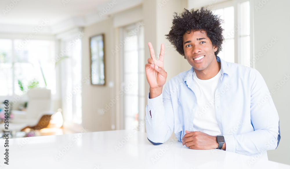 African American man at home showing and pointing up with fingers number two while smiling confident and happy.