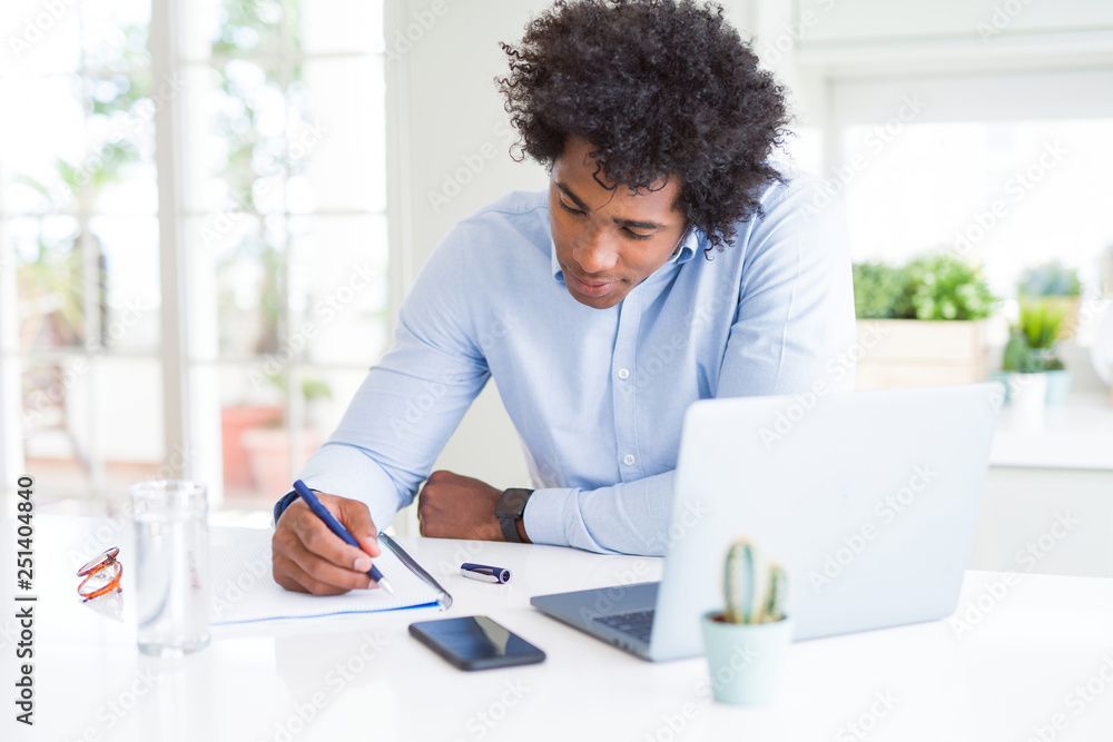 African American business man working writing on notebook with a confident expression on smart face thinking serious