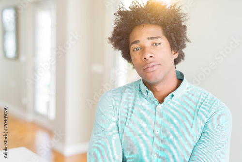 African American business man wearing elegant shirt Relaxed with serious expression on face. Simple and natural with crossed arms