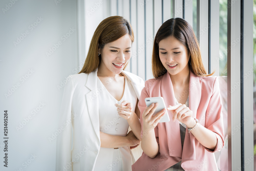 Asian business women group happy shopping online with tablet in city women shopping concept.asian women friends using smartphone talking smiling and laughing together at office. Asian business women group happy shopping online with tablet in city women shopping concept.asian women friends using smartphone talking smiling and laughing together at office.