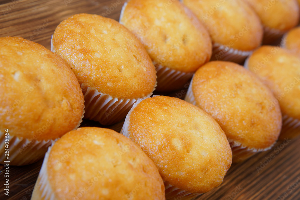 Golden cupcakes lie on a wooden surface of pine boards. Tasty and healthy food. Diagonal perspective and shallow depth of field. Daylight Golden cupcakes lie on a wooden surface of pine boards. Tasty and healthy food. Diagonal perspective and shallow depth of field. Daylight