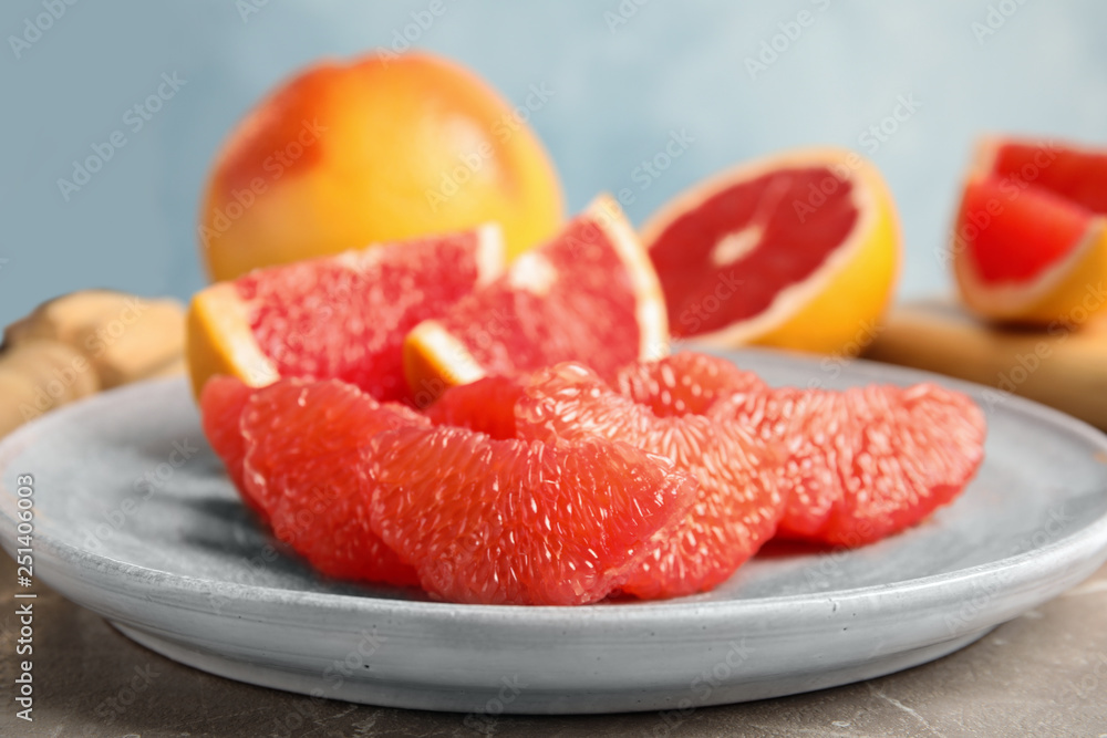 Plate with ripe grapefruit on table. Fresh fruit
