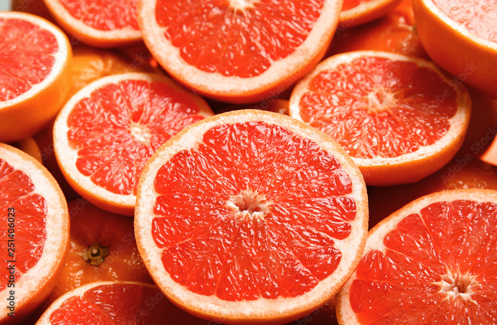 Many sliced fresh ripe grapefruits as background, closeup Many sliced fresh ripe grapefruits as background, closeup