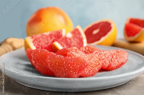 Plate with ripe grapefruit on table. Fresh fruit