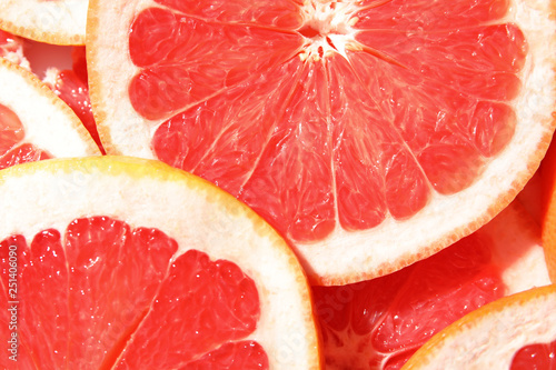 Many slices of fresh ripe grapefruits as background, closeup