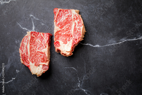  Raw Fresh Marbled Meat Beef Steak on the black marble Background Top View Copy space for Text
