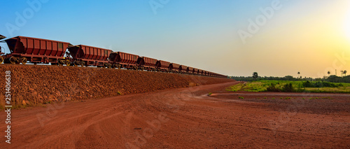 Railway carriages for transportation of bauxite ore on train tracks at the end of the railway line from bauxite mining. Guinea, Africa. photo