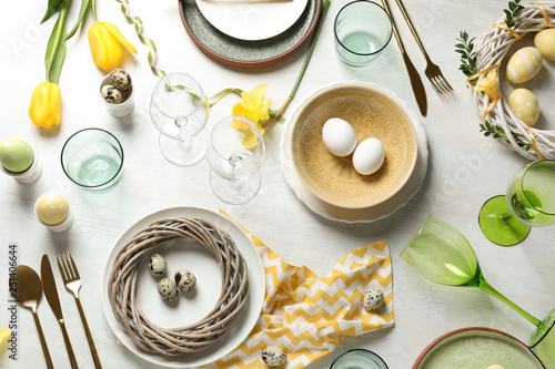 Festive Easter table setting with eggs on wooden background, top view