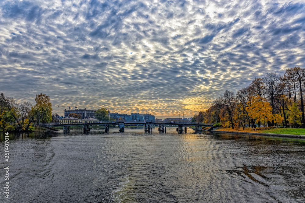 General view of Srednyaya (Middle) Nevka river shoreline and 1st Elagin bridge across in autumn. Saint-Petersburg, Russia.