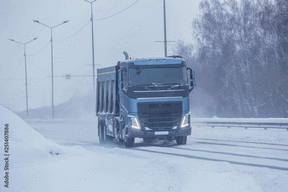 Truck  moves on a country highway in winter