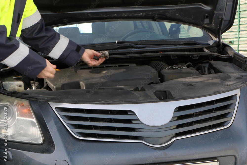 Fototapeta premium Close - Motor repair. Locksmith in a working jacket.