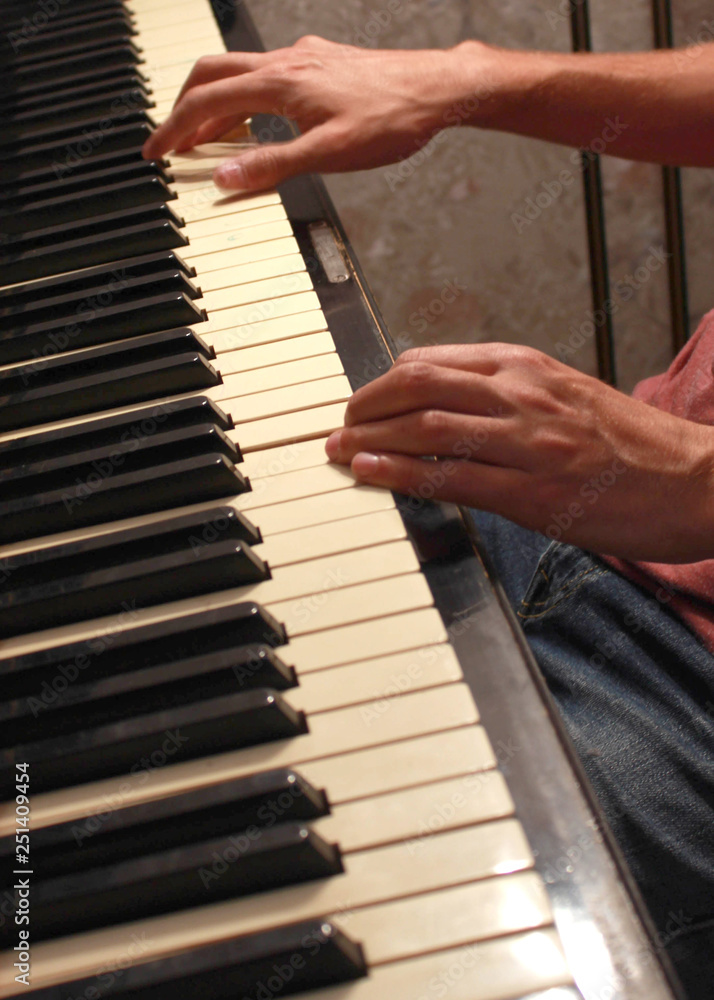 Close up of young boy hands, playing piano. vintage piano