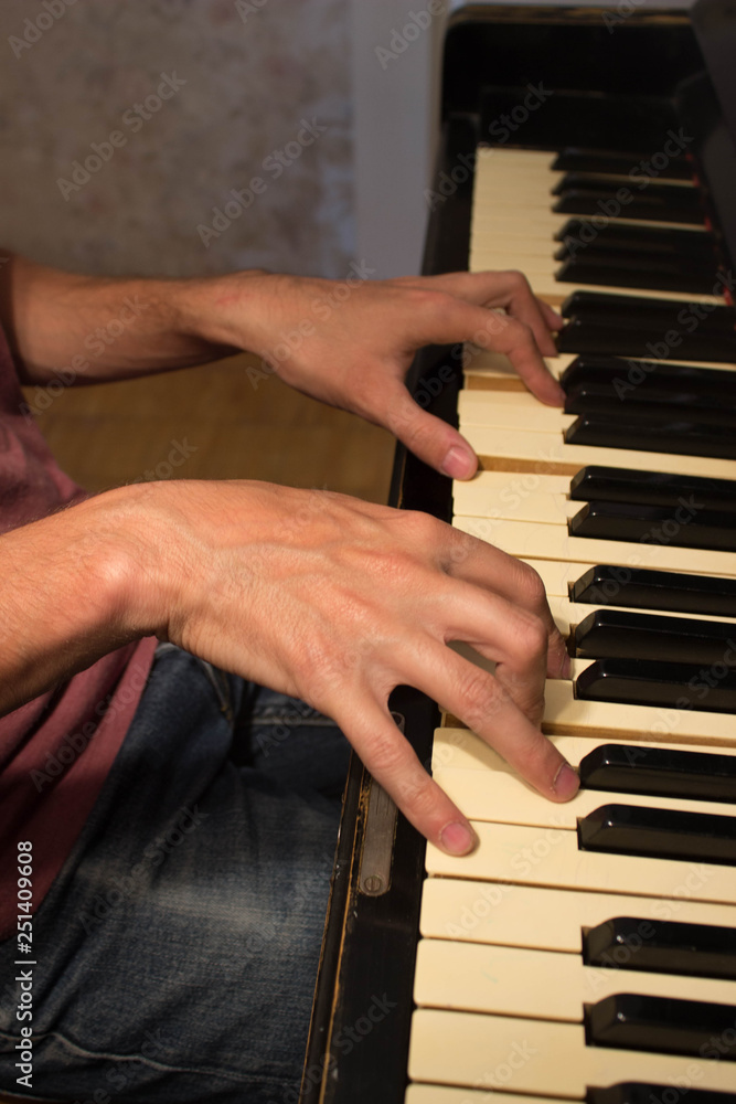Close up of young boy hands, playing piano. vintage piano