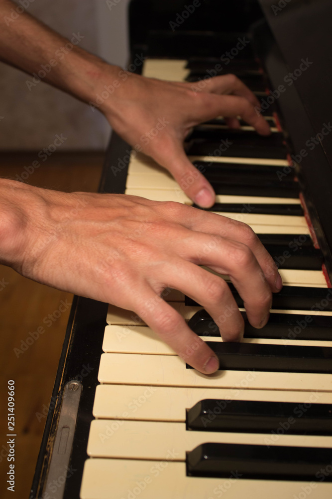 Fototapeta premium Close up of young boy hands, playing piano. vintage piano