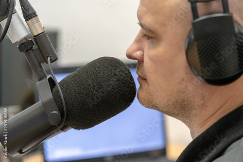 man radio DJ speaks into microphone close-up © borisblik