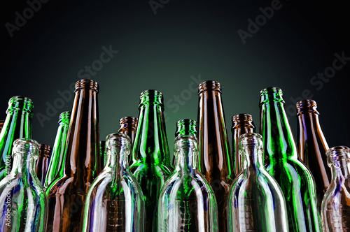 Empty and clean glass bottles on a dark background.