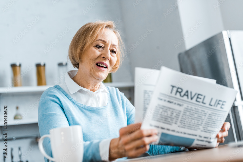 senior woman reading travel newspaper at home senior woman reading travel newspaper at home