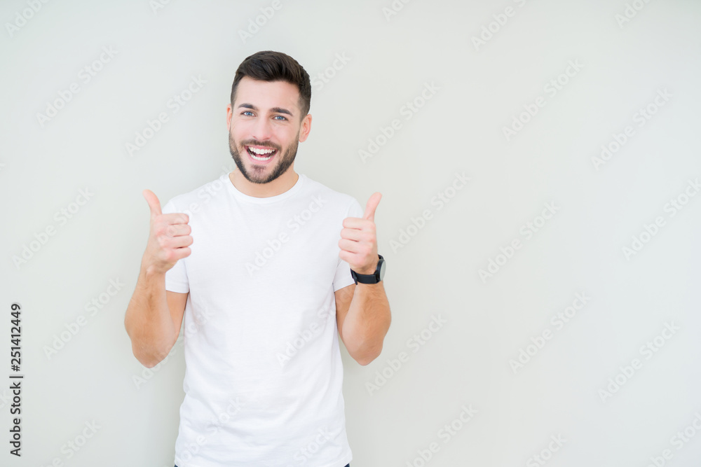 Young handsome man wearing casual white t-shirt over isolated background success sign doing positive gesture with hand, thumbs up smiling and happy. Looking at the camera with cheerful expression Young handsome man wearing casual white t-shirt over isolated background success sign doing positive gesture with hand, thumbs up smiling and happy. Looking at the camera with cheerful expression