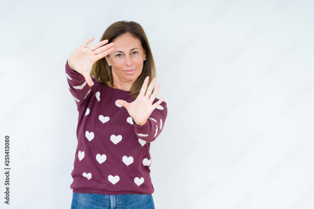 Beautiful middle age woman wearing heart sweater over isolated background Smiling doing frame using hands palms and fingers, camera perspective Beautiful middle age woman wearing heart sweater over isolated background Smiling doing frame using hands palms and fingers, camera perspective