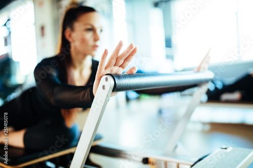 Two young females doing reformer exercises on pilates machines photo